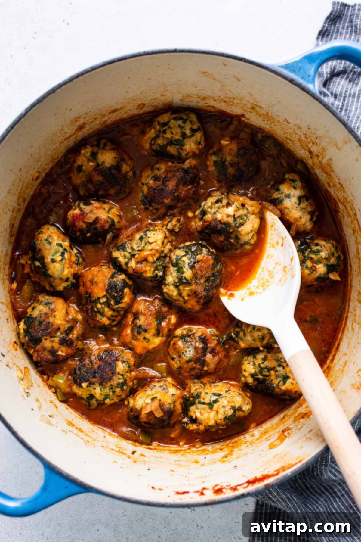 Meatballs in tomato sauce with a spoon.