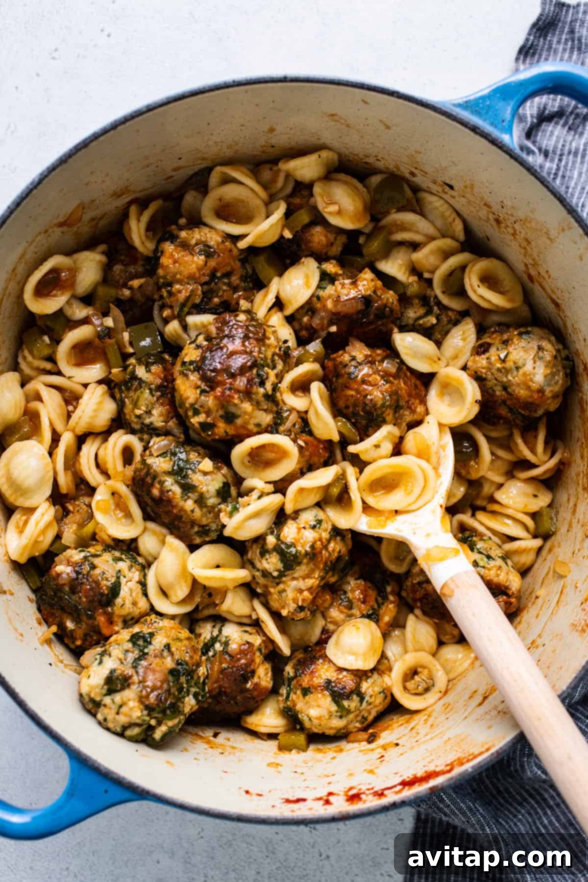 A pot filled with pasta and meatballs.