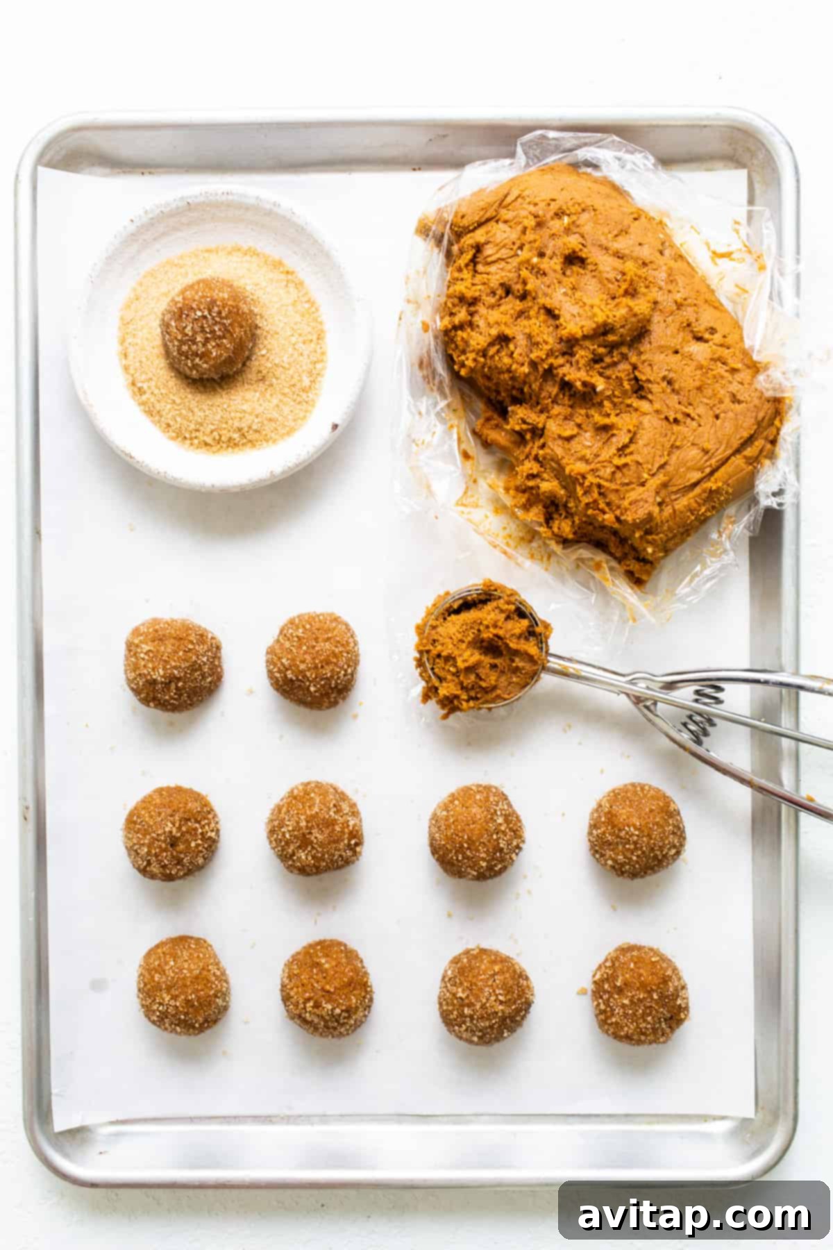 Warm Spiced Pumpkin Ginger Molasses Cookies 4 A baking sheet filled with unbaked cookie dough balls, perfectly spaced and rolled in turbinado sugar, ready for the oven.