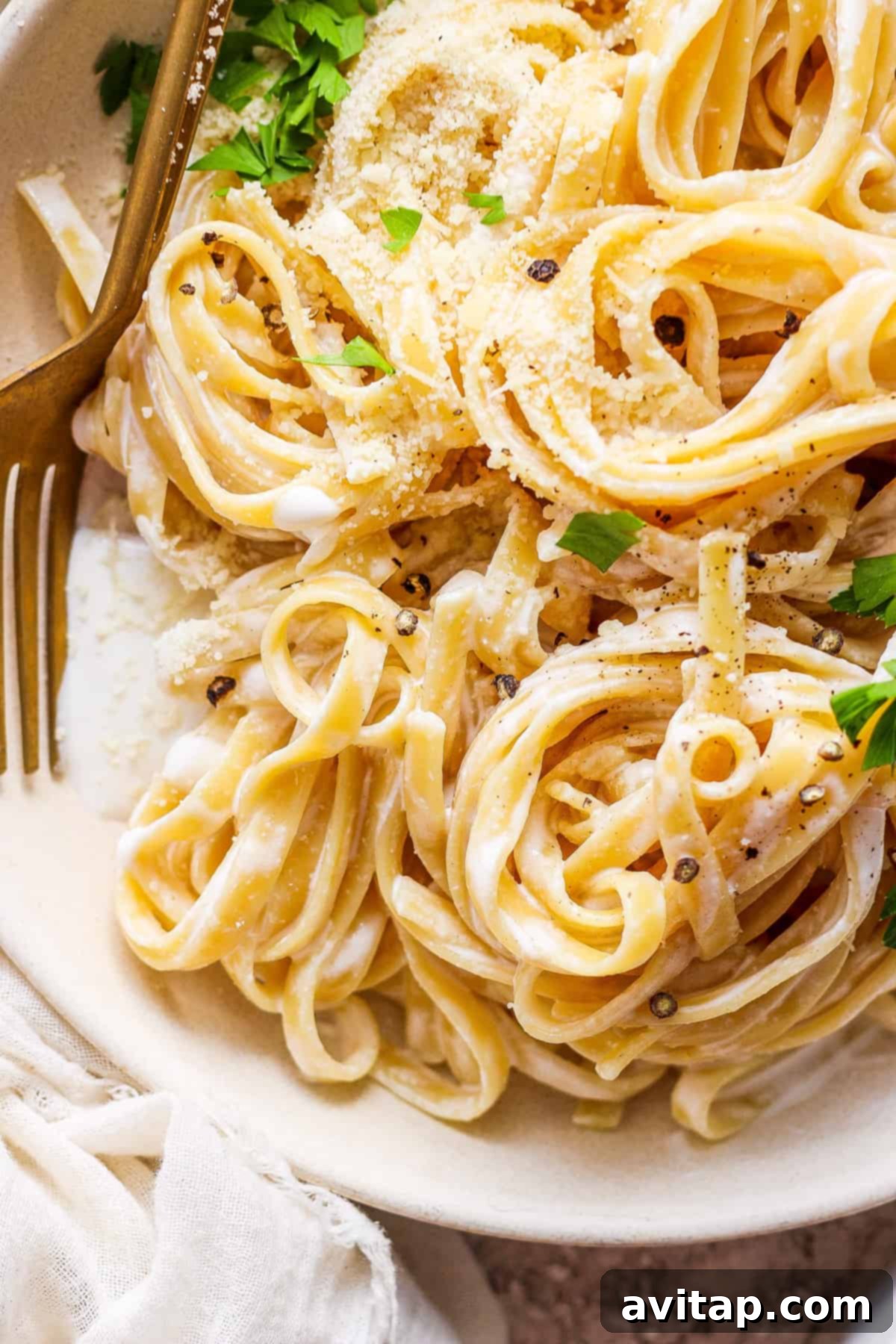 Creamy Cottage Cheese Alfredo 2 A bowl of high-protein cottage cheese Alfredo pasta with parmesan cheese and fresh parsley garnish.
