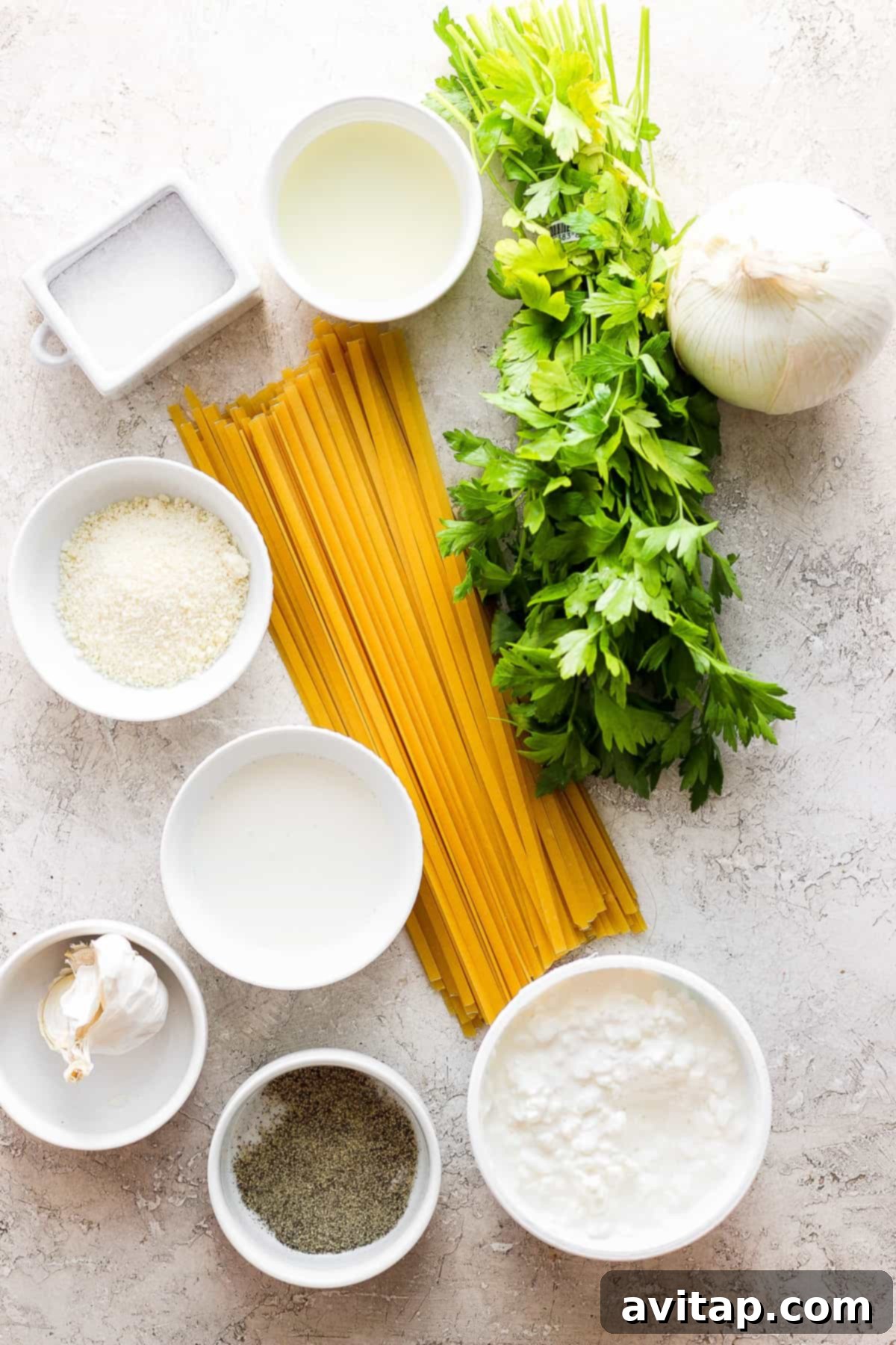 Creamy Cottage Cheese Alfredo 4 Fresh ingredients laid out for Cottage Cheese Alfredo: fettuccine pasta, olive oil, minced white onion, garlic cloves, cottage cheese, and fresh parsley.