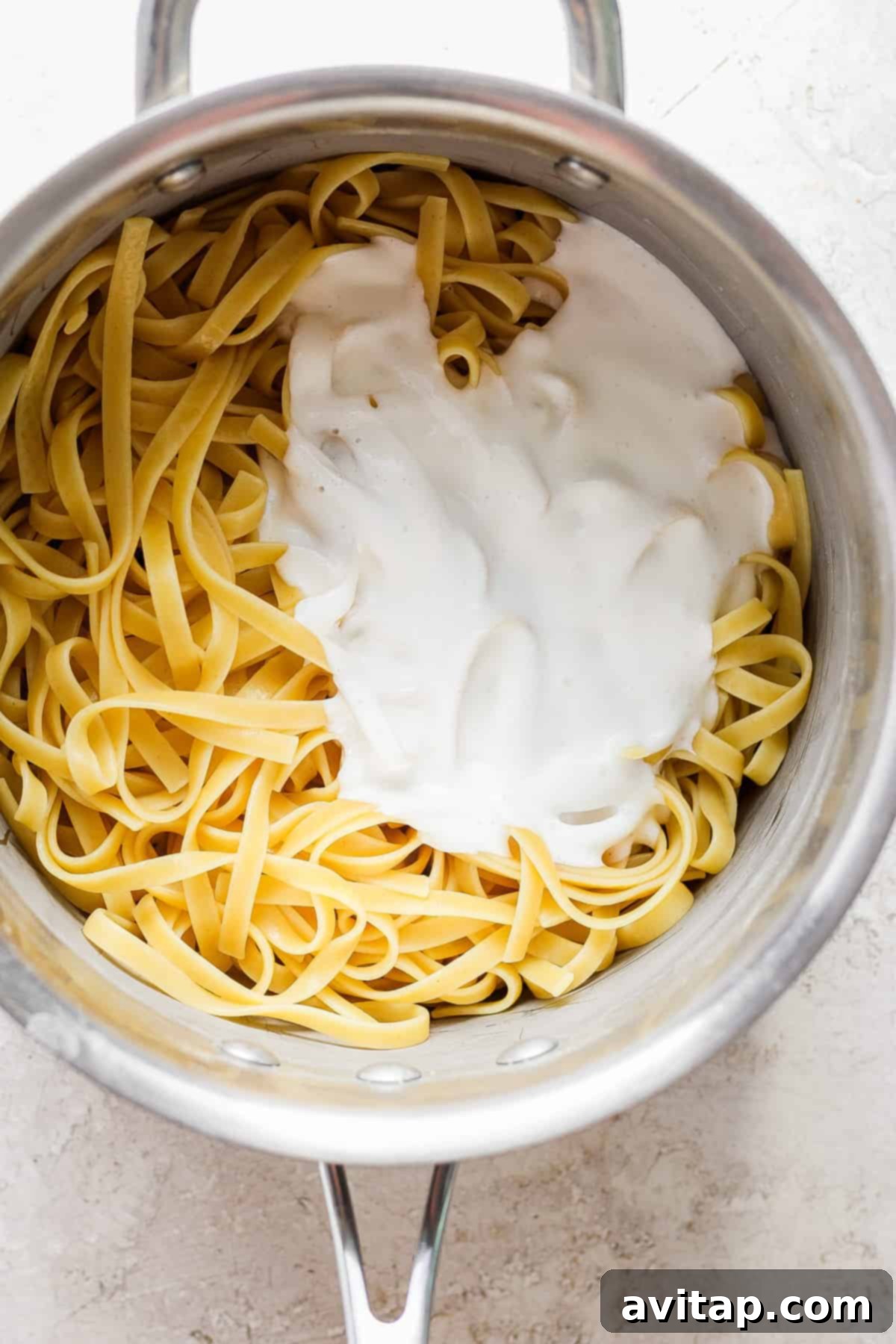 Creamy Cottage Cheese Alfredo 6 A pot of fettuccine pasta coated in creamy cottage cheese Alfredo sauce, ready to be served.