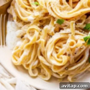 A beautifully plated bowl of Cottage Cheese Alfredo, garnished with fresh parmesan and parsley.