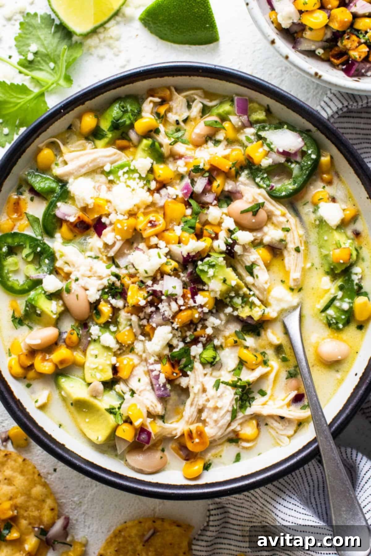 A bowl of delicious Street Corn Chicken Chili, garnished with fresh cilantro and served with crispy tortilla chips.