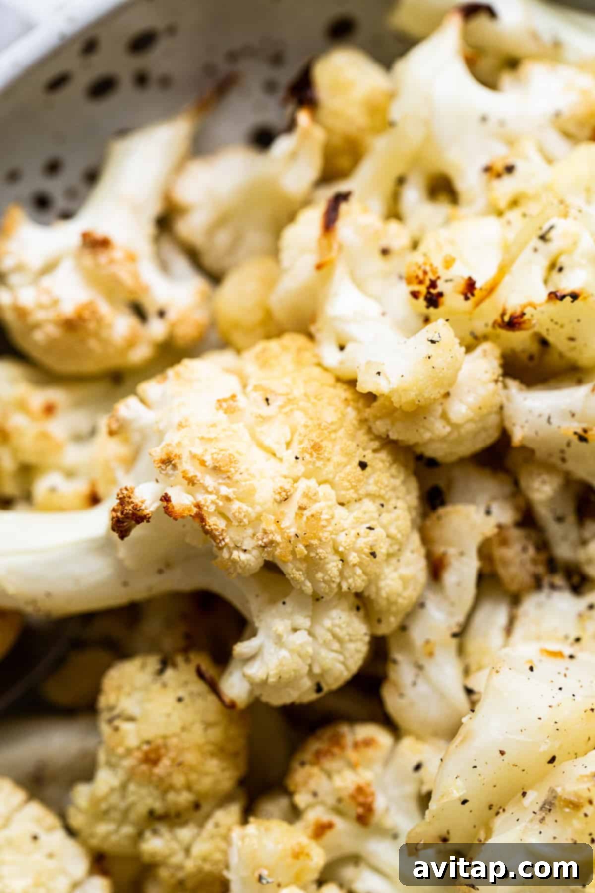 Close-up of a single perfectly roasted cauliflower floret, showing its golden-brown, caramelized edges and tender texture.