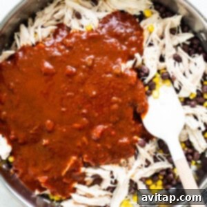 Mexican chicken in a skillet with sauce and corn.