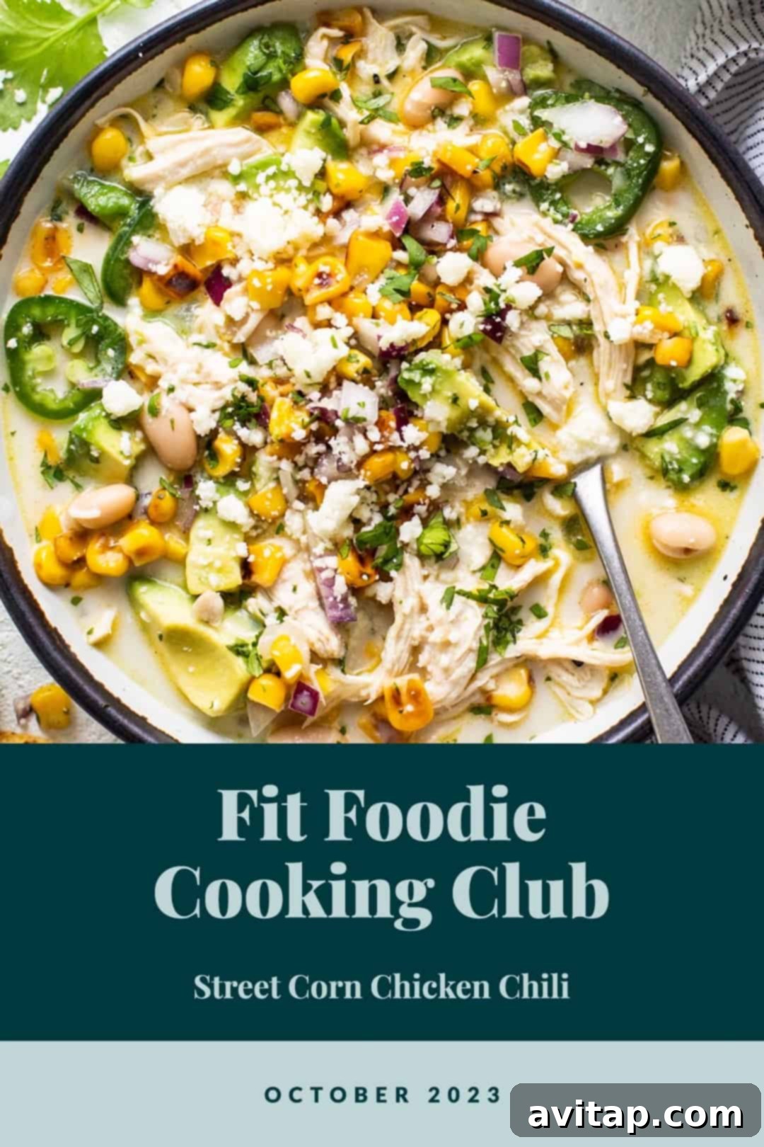 A vibrant bowl of Street Corn Chicken Chili, generously garnished with fresh cilantro, a squeeze of lime, and crumbled cheese, set against a cozy fall backdrop, inviting a warm and delicious meal.