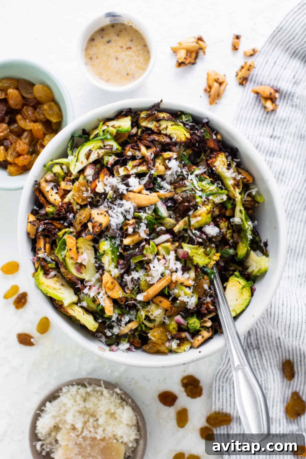 Crunchy Air Fried Brussels Salad 2 A bowl of brussels sprouts salad with nuts and raisins.