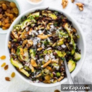 Crunchy Air Fried Brussels Salad 12 A bowl of brussels sprouts salad with nuts and raisins.