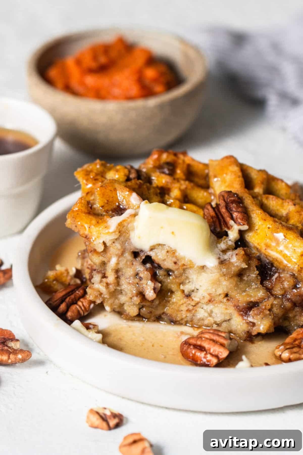 A plate featuring a golden-brown waffle slice adorned with chopped pecans, showcasing the delicious texture.