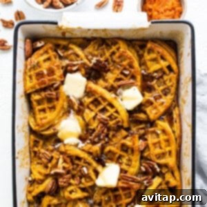 Pumpkin waffles in a baking dish with butter and pecans.