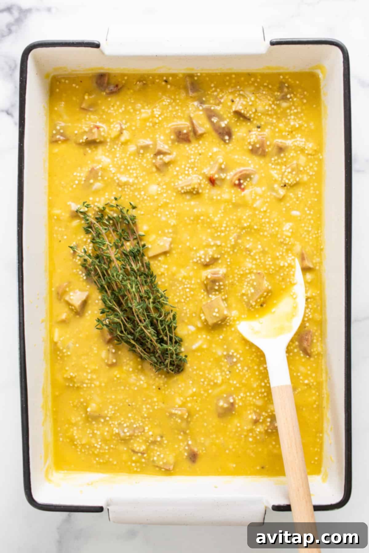 Cozy Butternut Quinoa Sausage Bake 5 A close-up of creamy butternut squash soup, garnished with a sprig of fresh thyme, highlighting the rich and inviting base of the casserole.