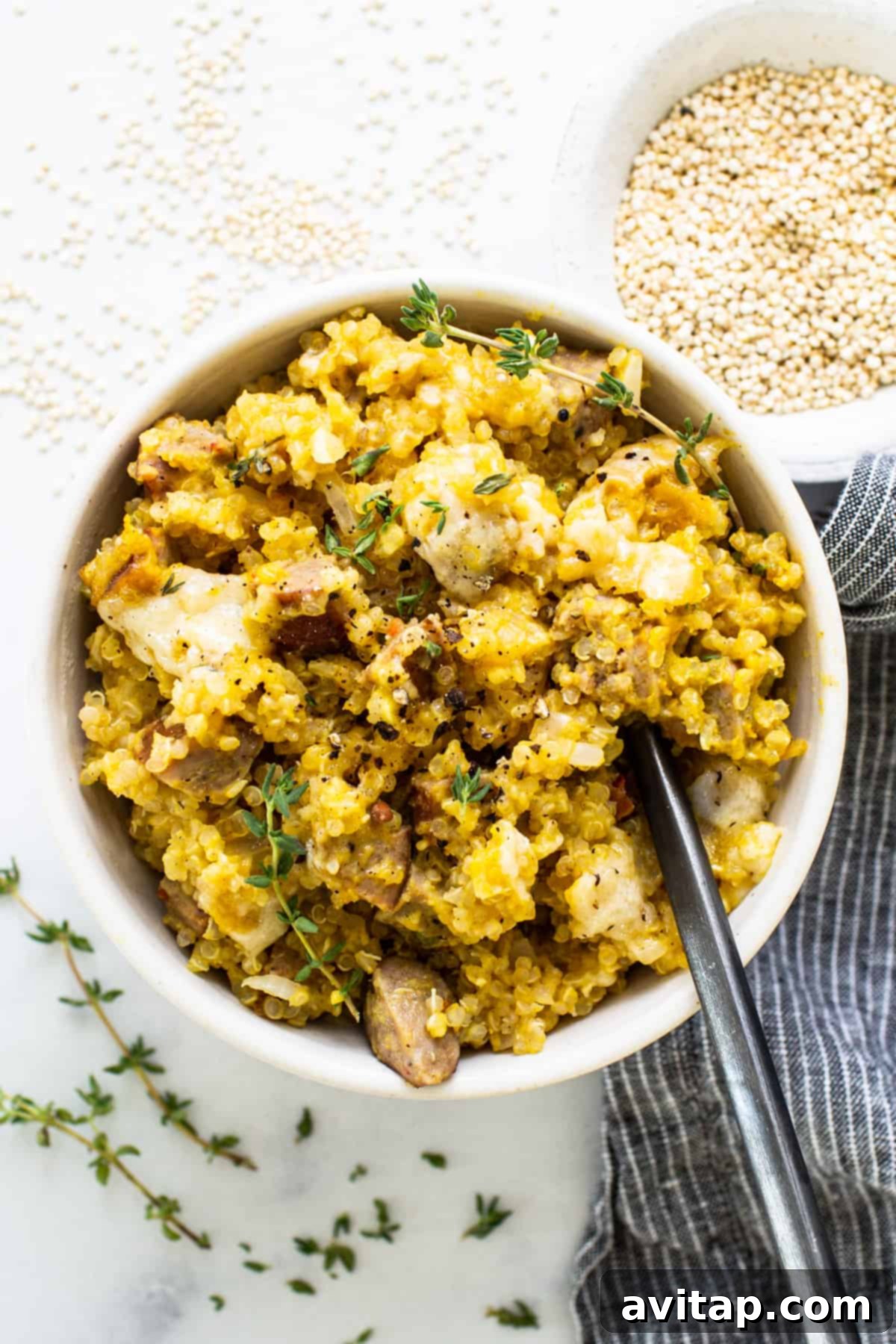 A close-up of a cozy, hearty bowl of a couscous-like dish, garnished with mushrooms and thyme.