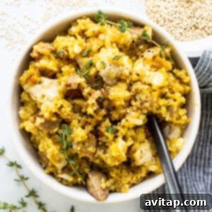 A beautifully presented bowl of butternut squash quinoa casserole, featuring hearty quinoa, savory chicken sausage, and a garnish of fresh thyme.