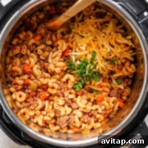 An instant pot full of macaroni and cheese with a wooden spoon.
