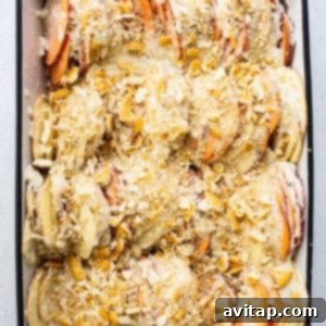 A baking dish filled with layered sweet potatoes and sauce, covered with a generous layer of crumbled Ritz cracker topping, ready for baking.