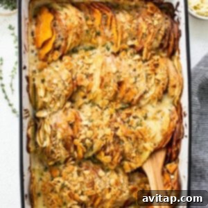 Sweet potato au gratin casserole in a baking dish with a wooden spoon, steaming and ready to be served, garnished with fresh herbs.