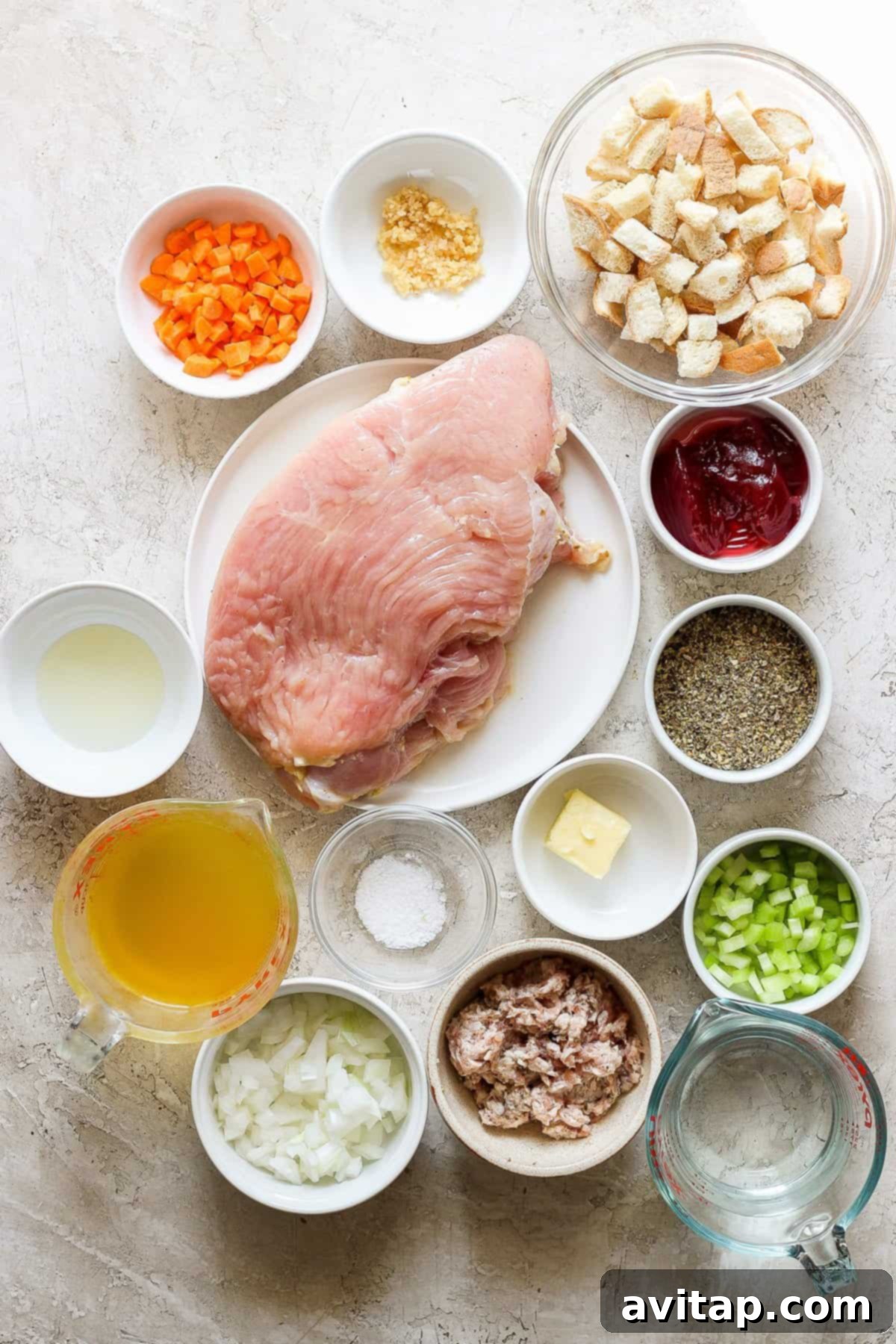 A selection of fresh ingredients including herbs, vegetables, and cranberry sauce, neatly arranged for preparing roasted turkey roulade.