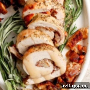 Roasted turkey roulade stuffed with sage and thyme, garnished and ready for serving.