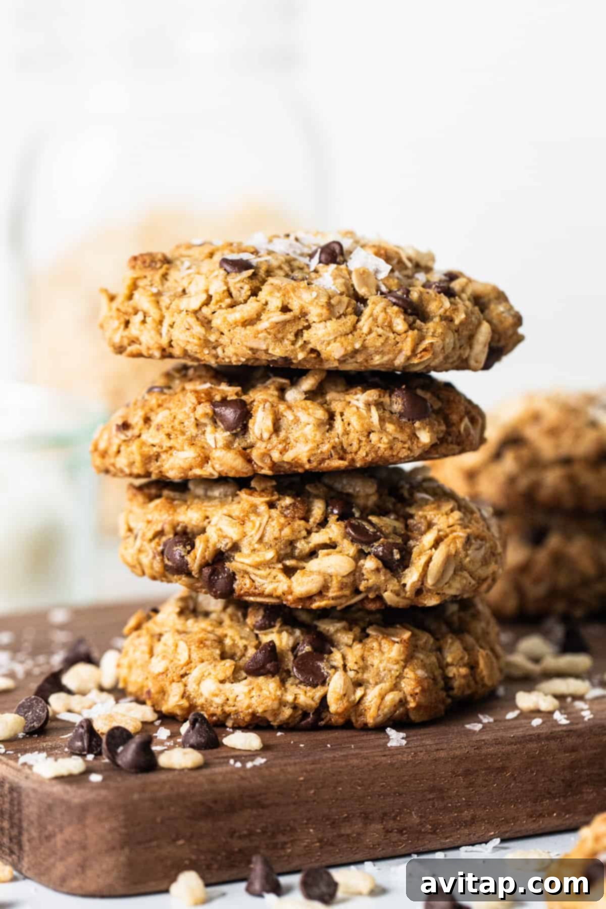 A stack of golden-brown flourless ranger cookies on a rustic cutting board, showcasing their delightful texture.