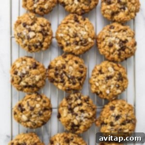 Freshly baked chocolate chip oatmeal cookies cooling on a wire rack.