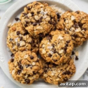 A plate of chocolate chip oatmeal cookies, garnished with sea salt, on a white plate.