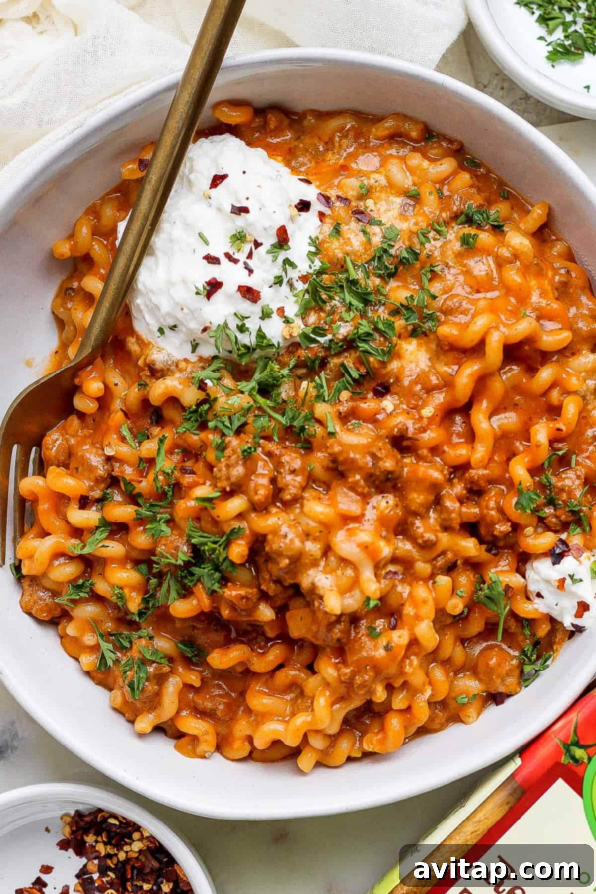 A generous serving of One-Pot Lasagna Pasta in a bowl, topped with a dollop of creamy whipped cottage cheese and fresh herbs.