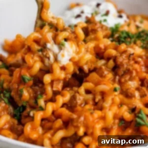 A rustic bowl of One-Pot Lasagna Pasta, garnished with fresh parsley and Parmesan, showing off its creamy texture and rich sauce.