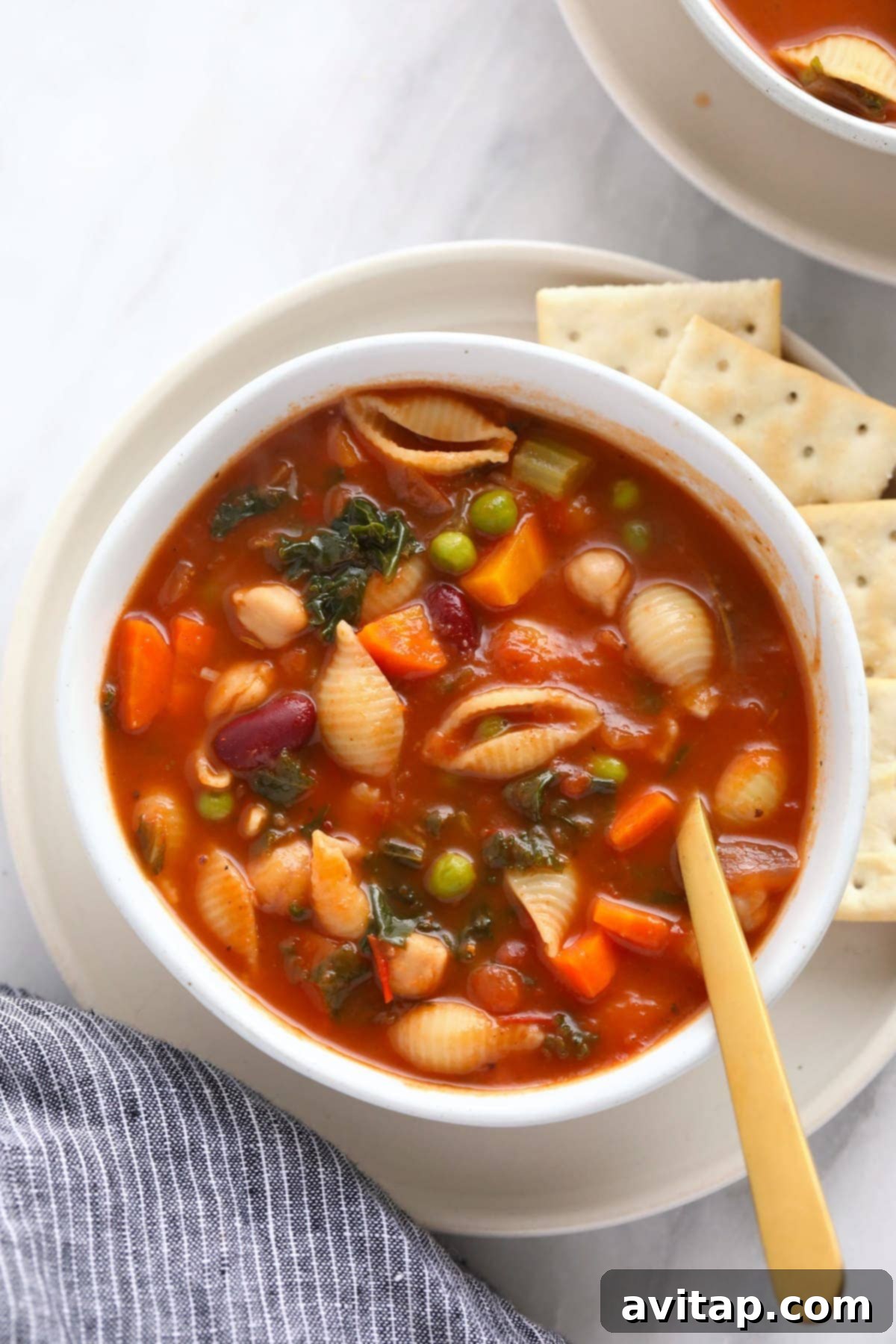 Make this vegetable packed minestrone soup and eat it all week long! A steaming bowl of classic minestrone soup, garnished with fresh herbs and served with crackers on the side.