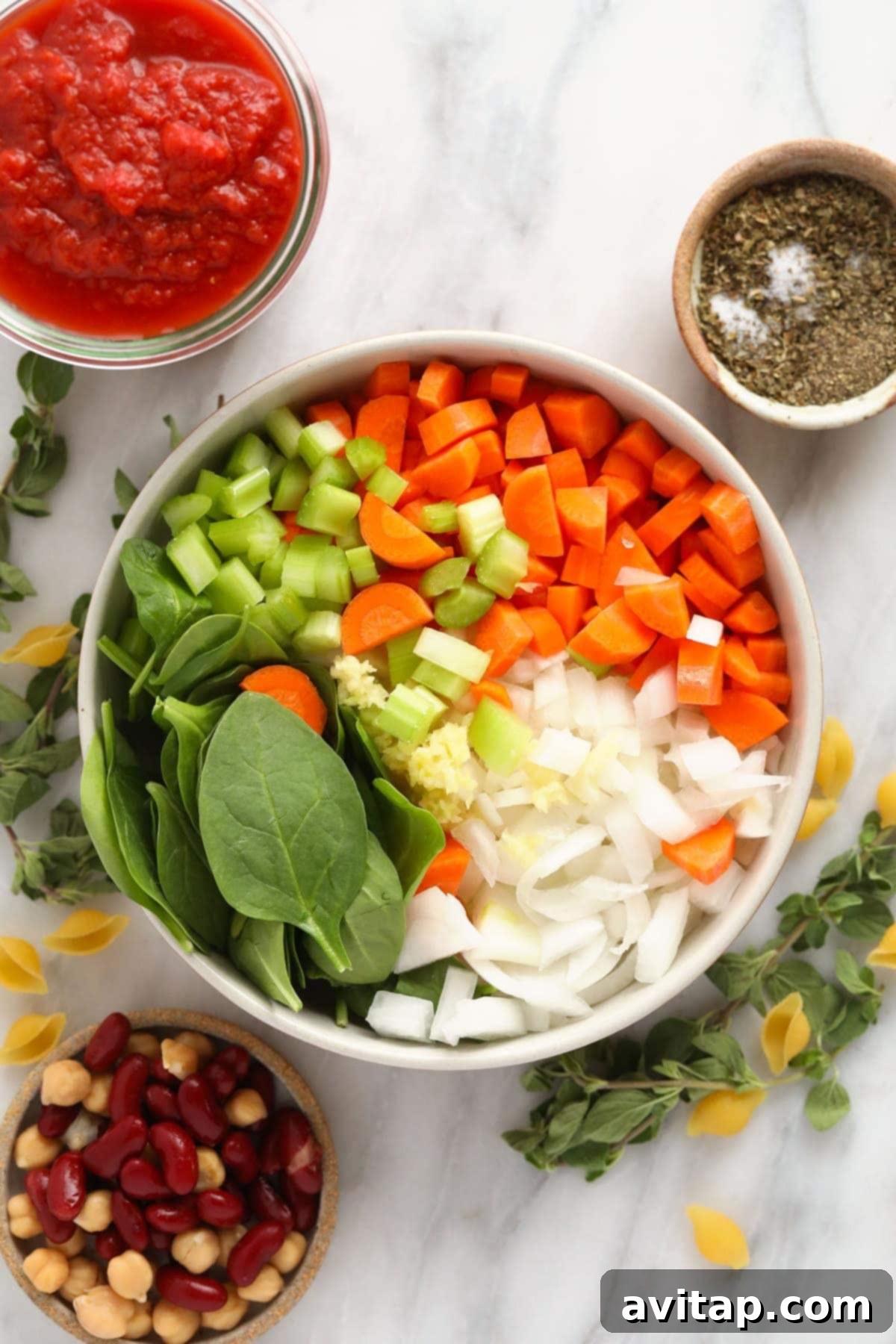 Make this vegetable packed minestrone soup and eat it all week long! A collection of fresh vegetables including carrots, celery, onion, garlic, and spinach, prepared for minestrone soup.