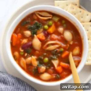 A bowl of Minestrone Soup served with crackers, ready to enjoy.