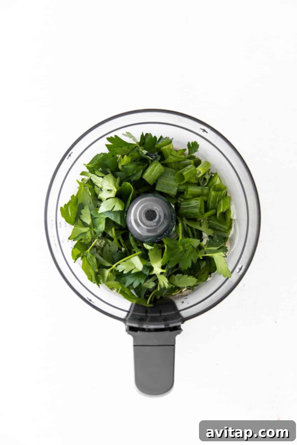 All the fresh ingredients for Green Goddess Dressing gathered in a food processor, ready for blending.