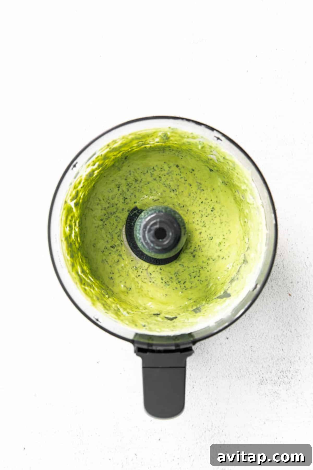 Creamy Green Goddess Dressing being blended in a food processor to a smooth consistency.