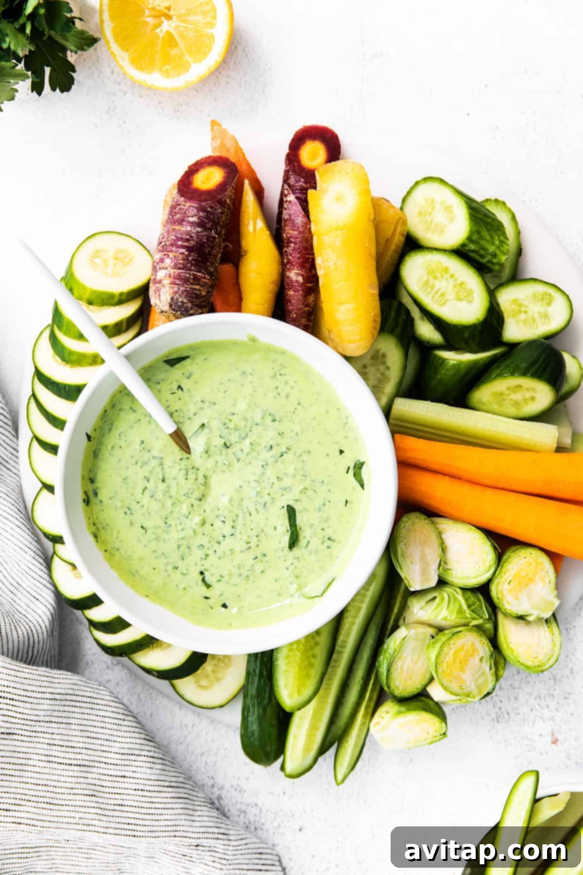 A bowl of creamy Green Goddess Dressing, garnished with fresh herbs, ready for serving.