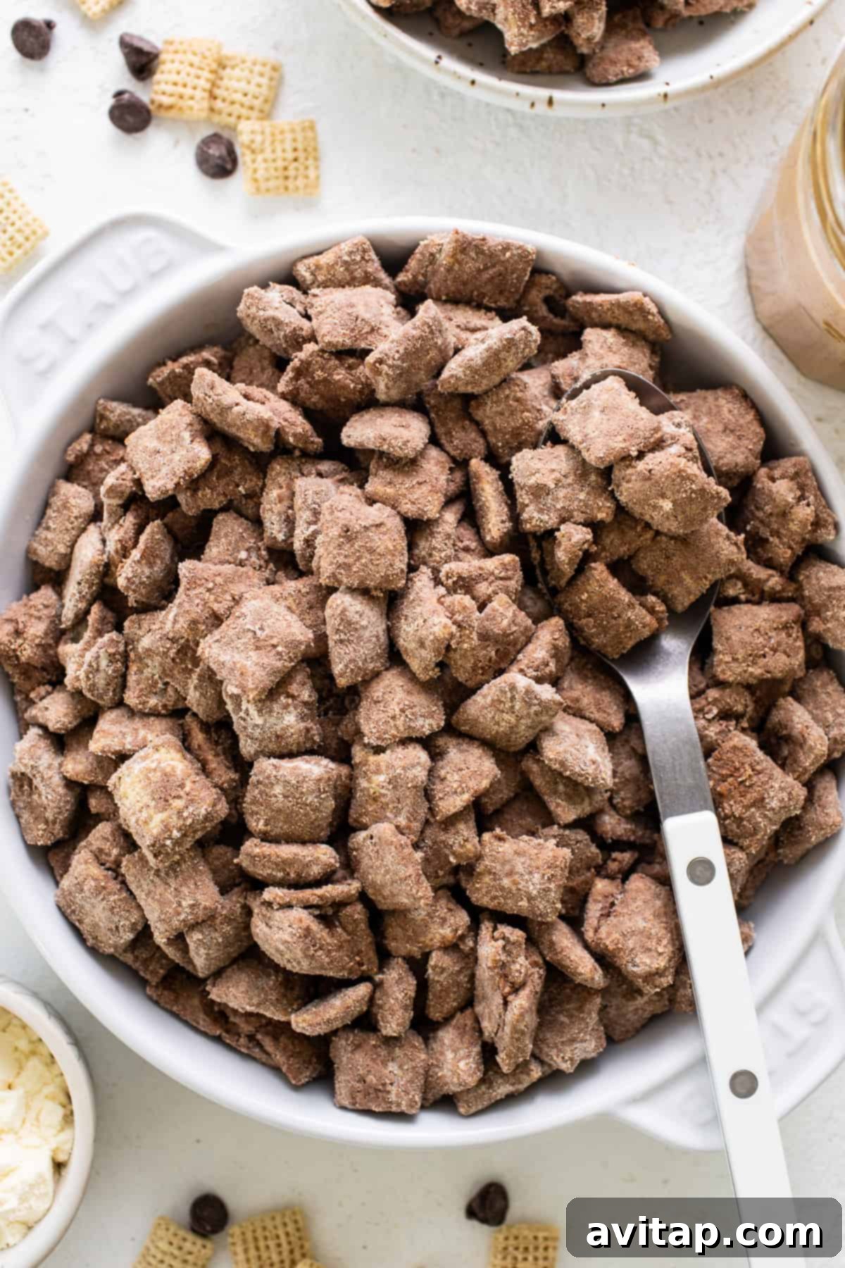A large bowl filled with tempting chocolate peanut butter protein puppy chow, ready to be enjoyed with a spoon.