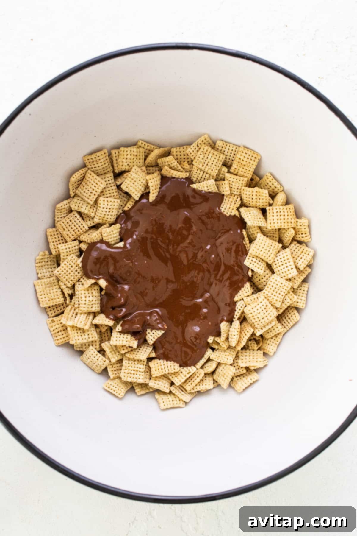 A large bowl brimming with chocolate-coated Chex cereal, highlighting the delicious texture and even coating.