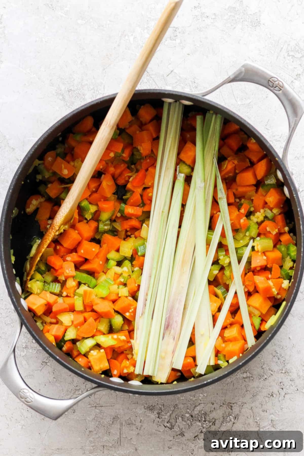 A large pot filled with sautéing carrots, onions, and celery for the soup base.
