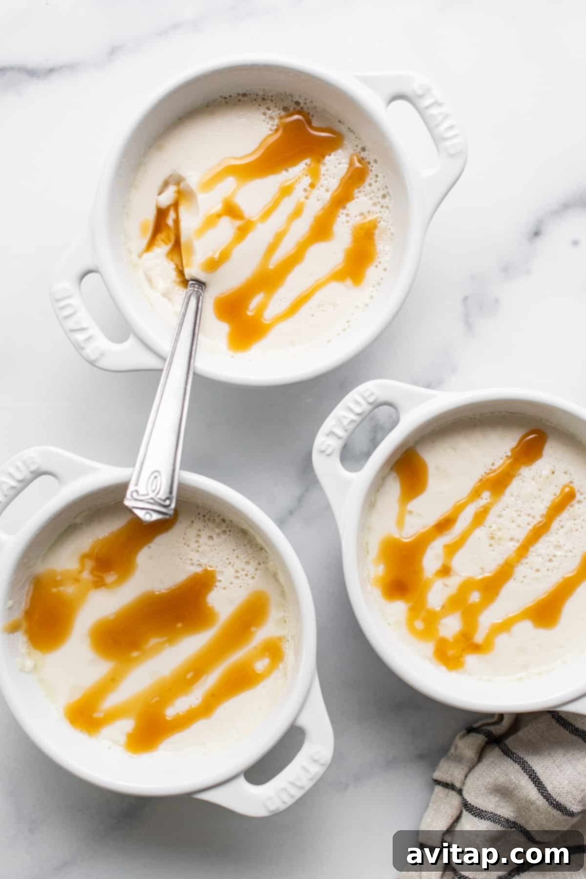 Three ramekins filled with panna cotta, chilling to perfection, ready for topping with caramel.