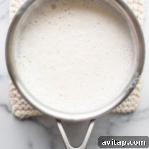 A pan with milk in it on a marble countertop.