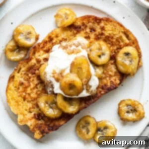 A plate of french toast with bananas and whipped cream, ready to serve.