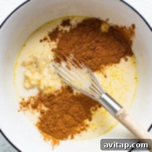 A bowl with cinnamon, sugar, and a whisk, illustrating the custard preparation.