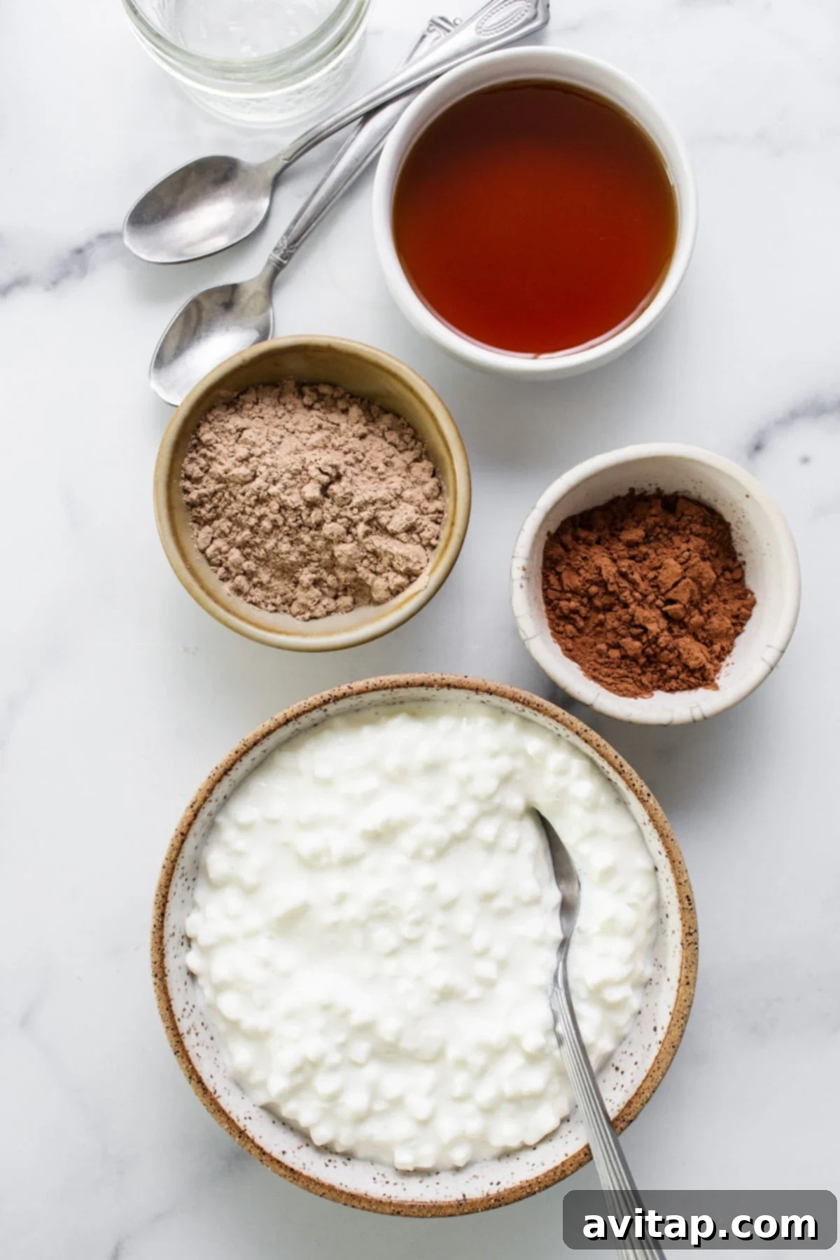 A bowl of yogurt with ingredients on a marble table.