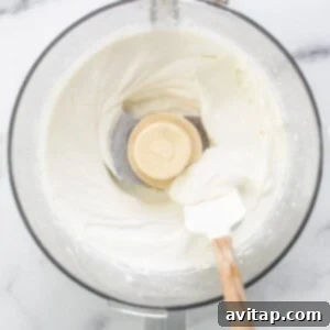 Whipped cream in a mixing bowl with a wooden spoon.