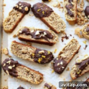 Delicious square-shaped image of gluten-free almond biscotti with dark chocolate drizzle and orange zest. Keywords: Gluten-Free, nuts