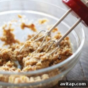Gluten-Free Almond Biscotti 6 An electric hand mixer mixing almond flour biscotti dough in a glass bowl.