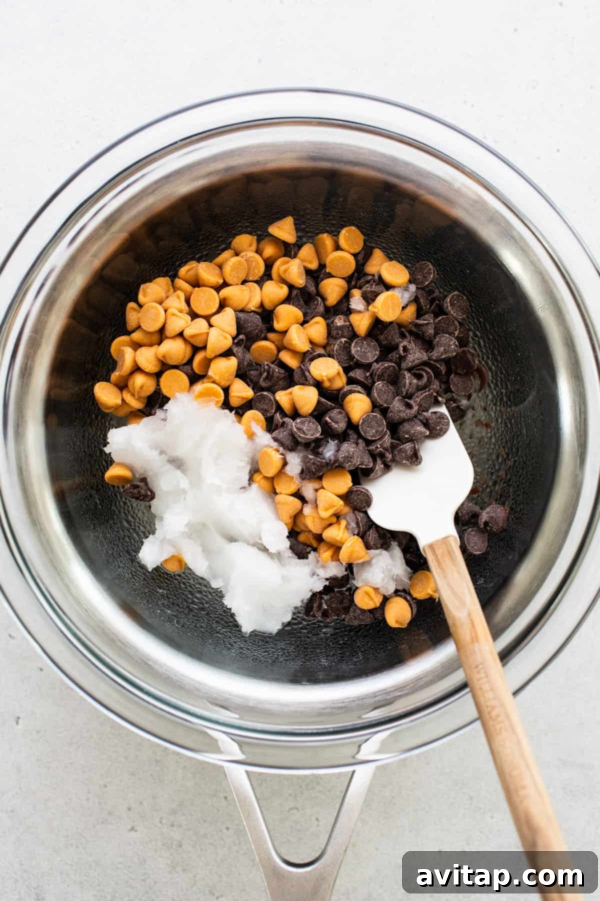 Protein Power Scotcheroos 4 Close-up of semi-sweet chocolate chips ready for melting in a bowl with a wooden spoon.