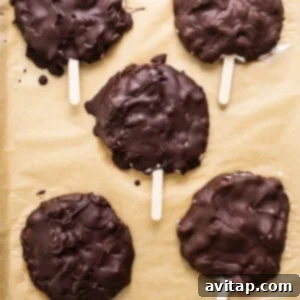 Chocolate covered frozen yogurt bars on a baking sheet after dipping, solidifying quickly.