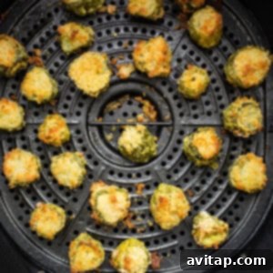 Crispy, golden-brown air-fried pickles fresh from the air fryer basket, ready to be served.