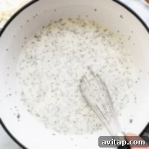A person whisking chia seeds into a bowl of liquid ingredients.