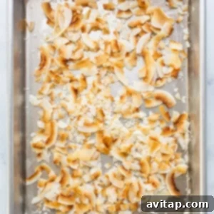 A metal pan filled with shredded coconut on a counter, ready for toasting.
